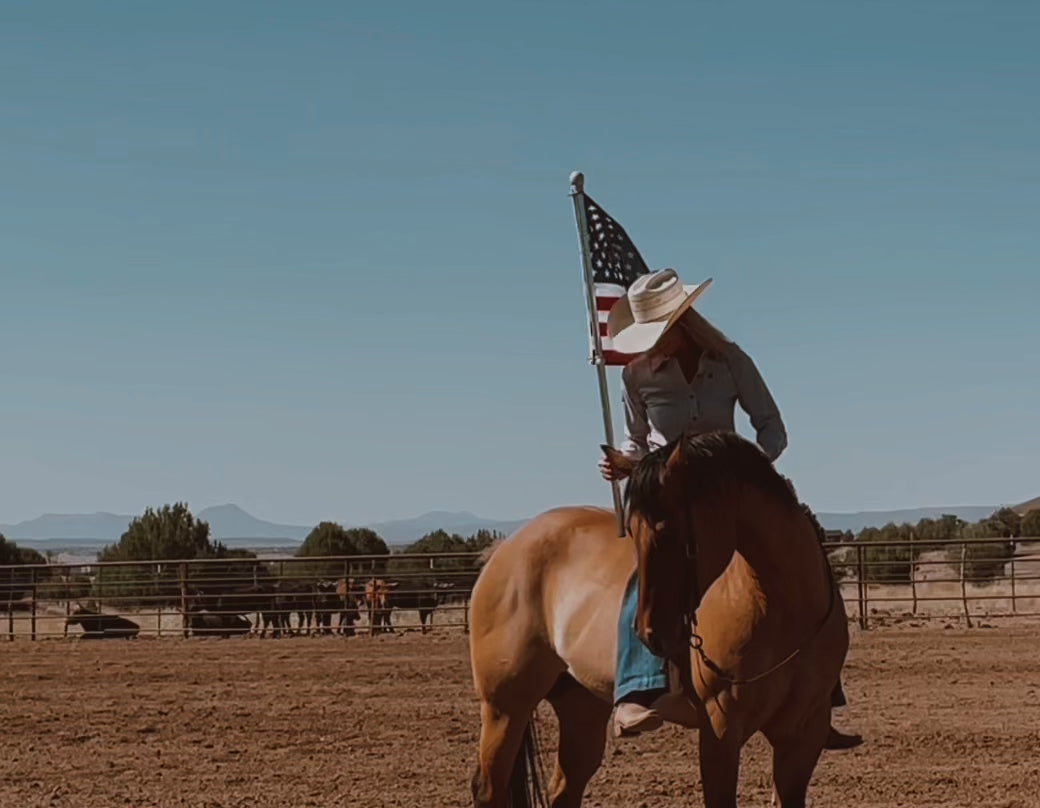 Load video: Cowgirl on horse with flag